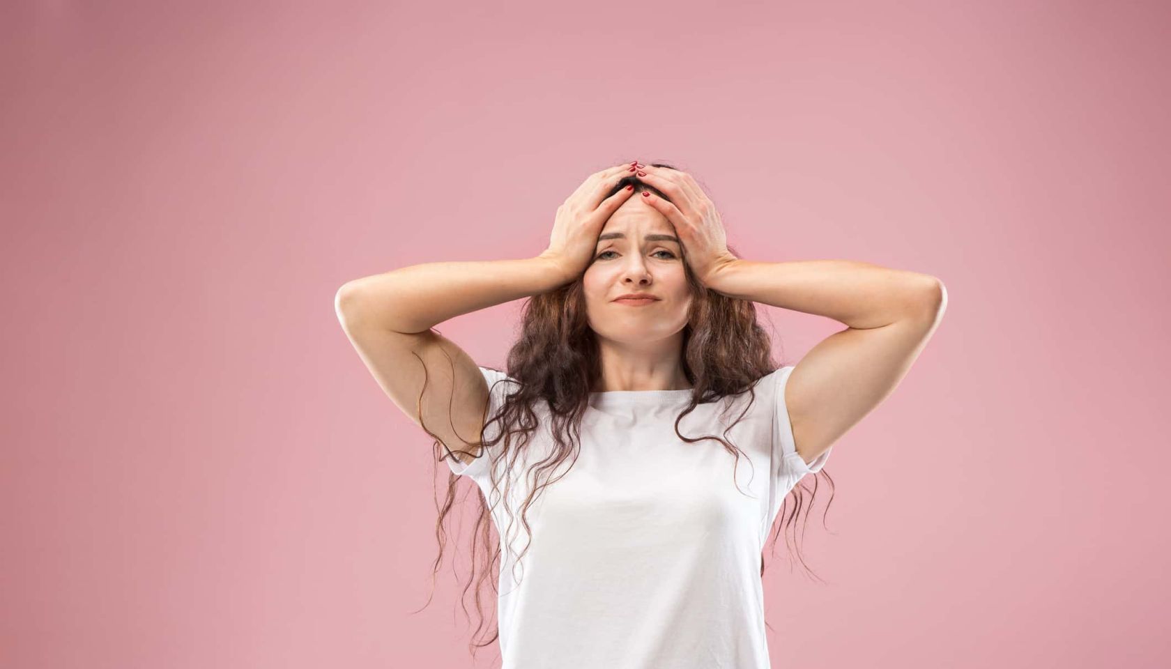 Woman having headache. Isolated on pink background. Businesswoman standing with pain isolated on trendy studio background.