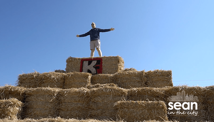 Sean Copeland standing on top of hay mountain at Kelsay Farms