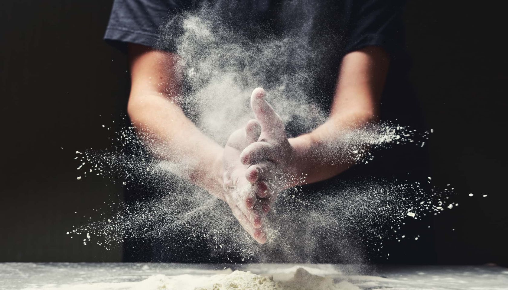 Clap hands of baker with flour in restaurant kitchen