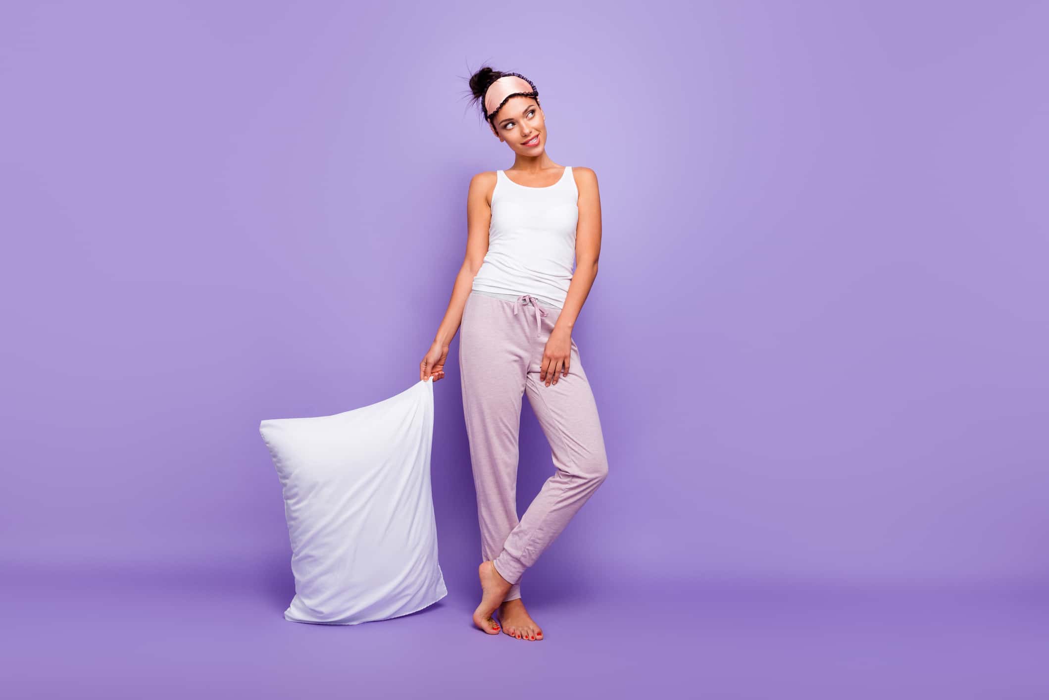 Full length body size photo beautiful she her lady look empty space wondered thoughtful hold hand arm pillow barefoot wear sleeping mask pants tank-top pajamas isolated violet purple background.
