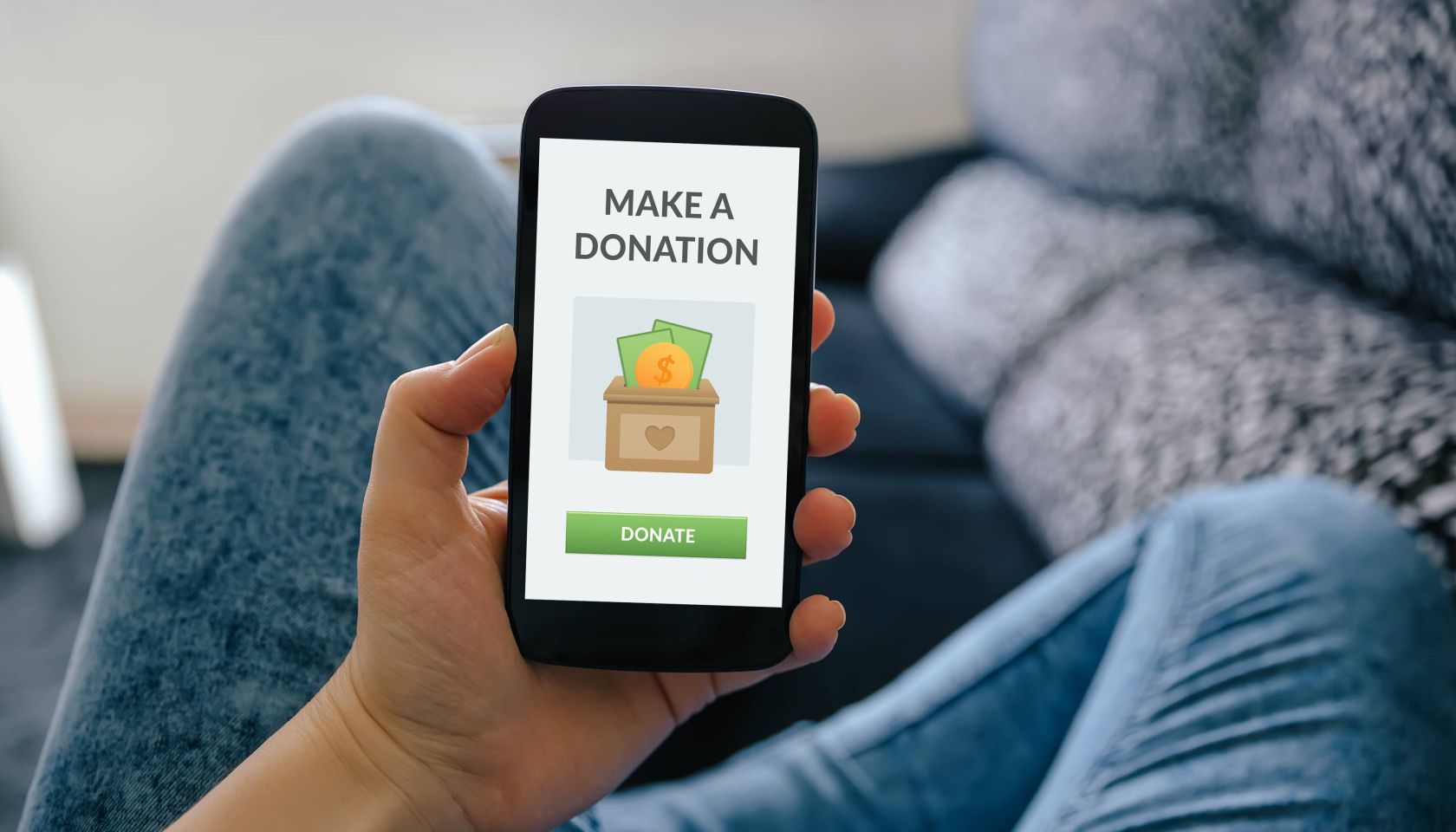 Girl holding smart phone with donation concept on screen