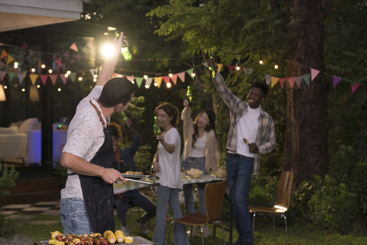 Group of youngsters in backyard having fun at barbecue party.