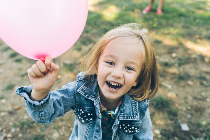 Playful child with pink balloon outdoors