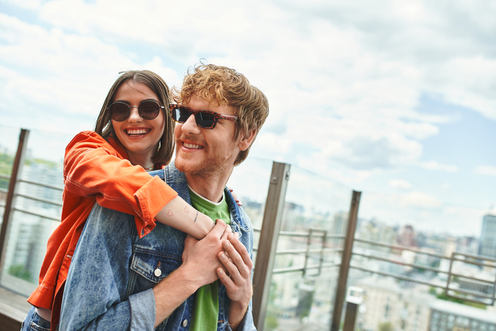 A joyful couple enjoying a romantic rooftop date against a stunning city skyline backdrop