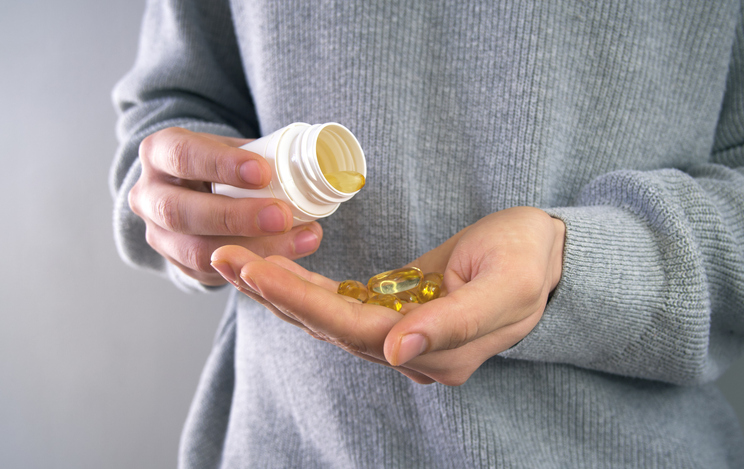 Male pouring a Fish oil his hand. Fish oil capsules, omega 3, omega 9, vitamin D, vitamin E