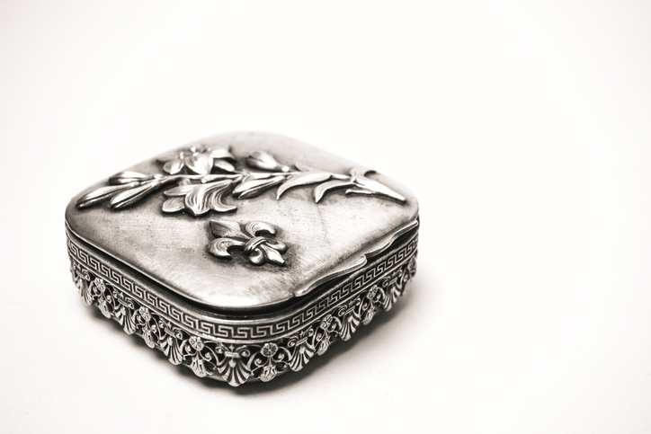 Antique silver box with a pattern on a white background