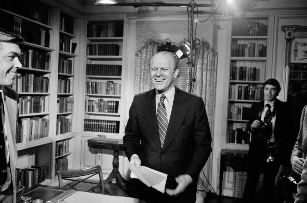 US President Gerald Ford standing and smiling after giving a television speech at the White House, Washington