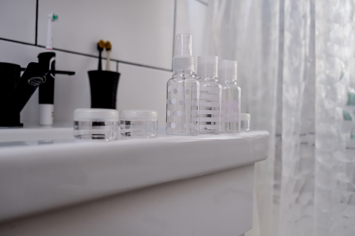 Empty set of mini travel jars with cosmetics and care products in transparent bag