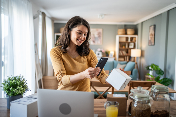 Woman managing her small business from home taking pictures of products