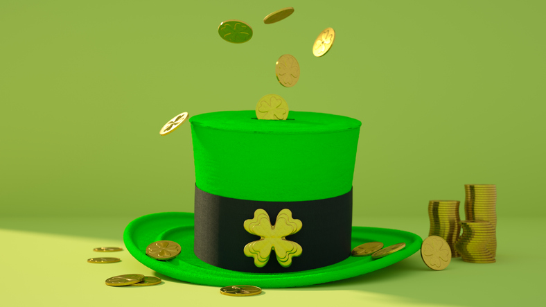 Green leprechaun hat with gold coins falling into it and stacks of coins nearby, celebrating saint patrick's day