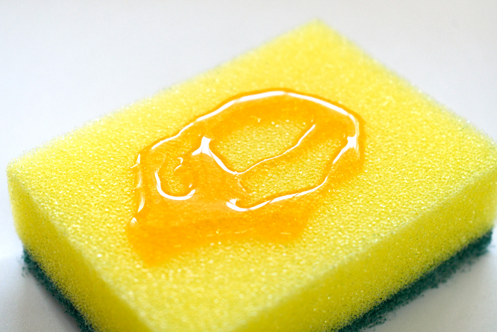Yellow sponge and scrub pad with dishwashing liquid.