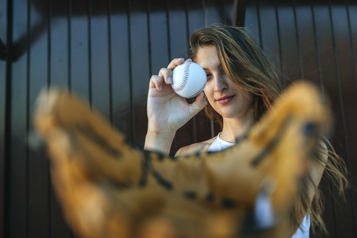 Woman with baseball ball and glove outdoors