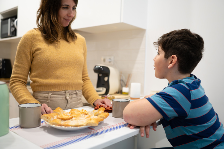 Mother and son sharing a sweet moment in the kitchen over focaccia bread