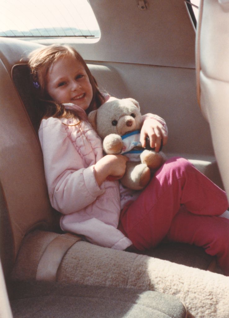 1980s Child in backseat wearing seatbelt during car ride