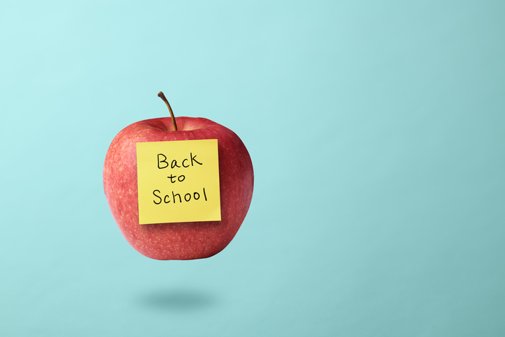 Red apple with a yellow sticky note attached "Back to School" written on it