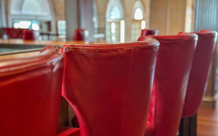 row of high back barstool chairs at bar