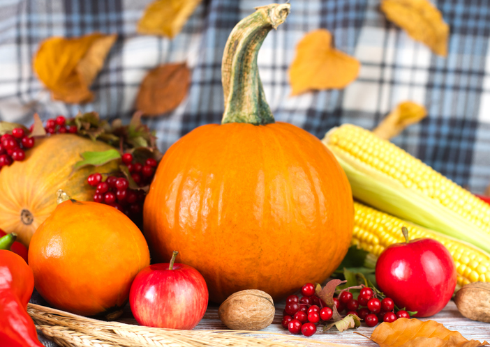 Pumpkins, vegetables, fruit and autumn leaves on the wooden background. Autumn harvest. Happy Thanksgiving. Close-up.