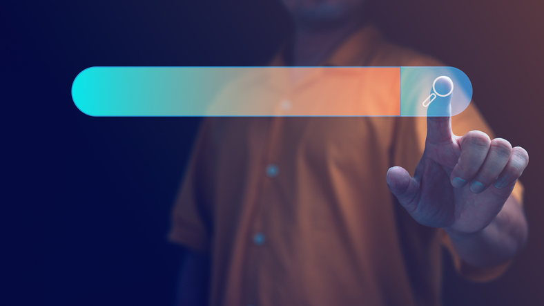 Interactive search bar interface photograph showcasing a person's touch interaction, symbolizing digital engagement and information retrieval.