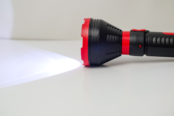 Powerful LED Flashlight Emitting Bright Beam of Light on White Surface