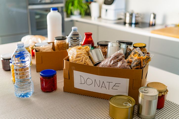Donation boxes full of canned or nonperishable food on kitchen counter. Charity, emergency planning or social services