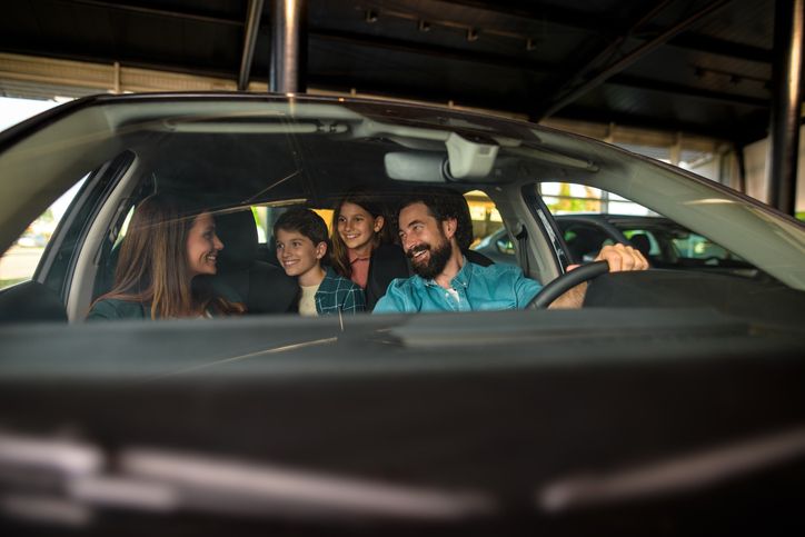Happy family buying a new car at auto dealership